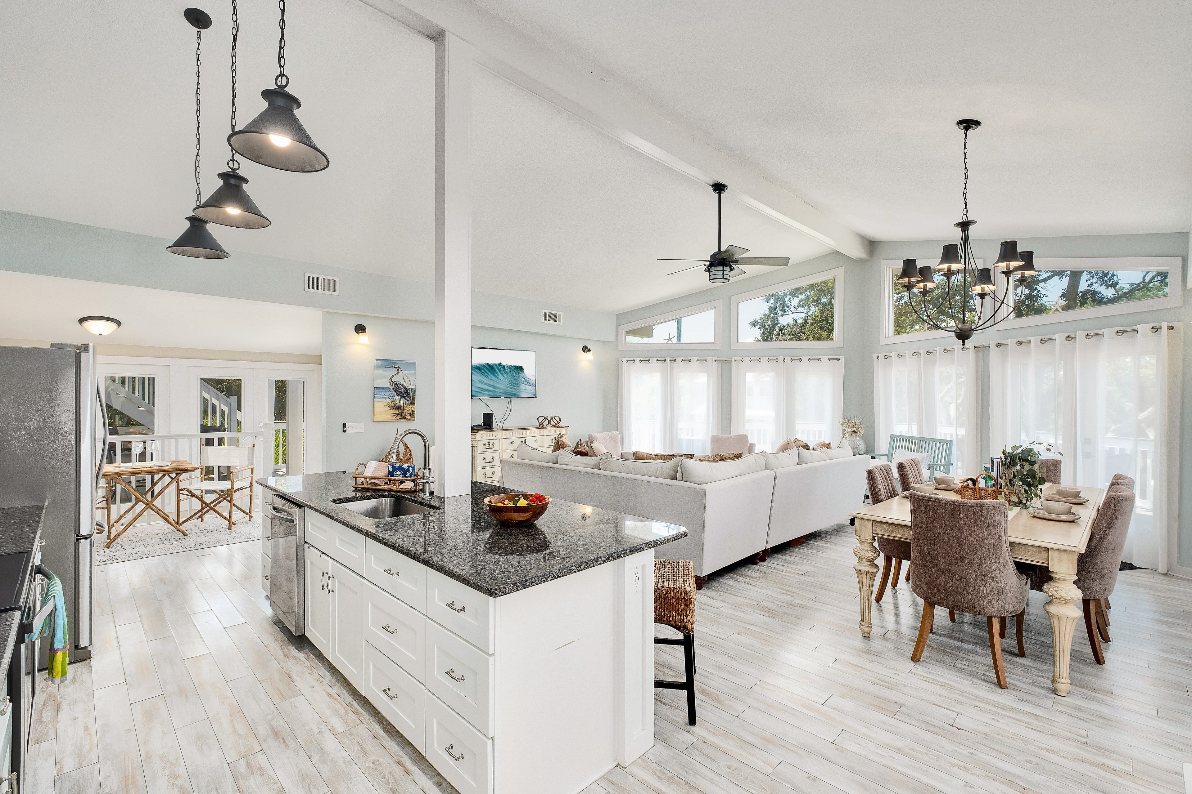 A spacious kitchen with a large island, a dining area with a table and chairs, and a ceiling fan.
