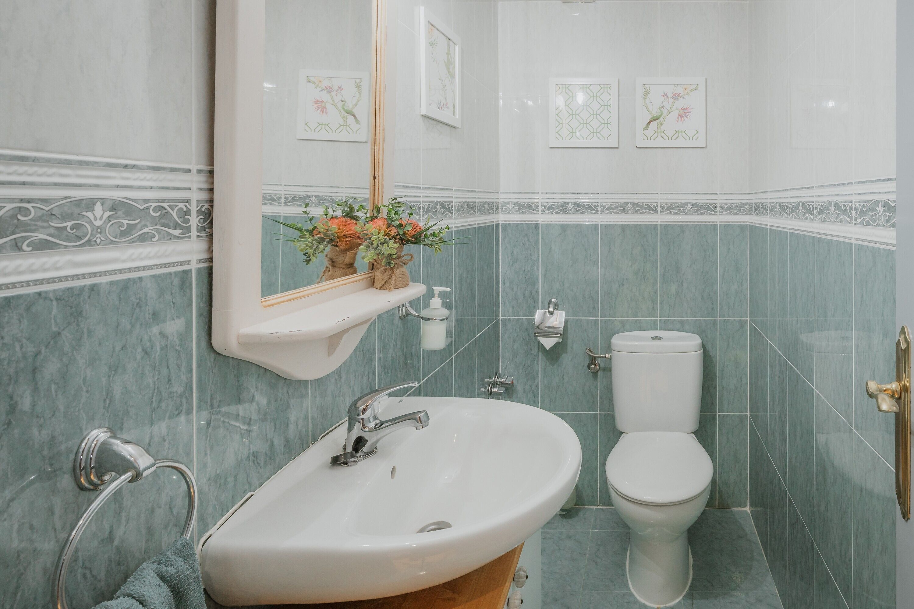 Une salle de bain avec un lavabo, des toilettes et un miroir.