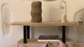 A wooden shelf with a textured vase, a lamp, and two books. - Two Bedroom Suite with Balcony, Spartacus Garden (Rethymno)
