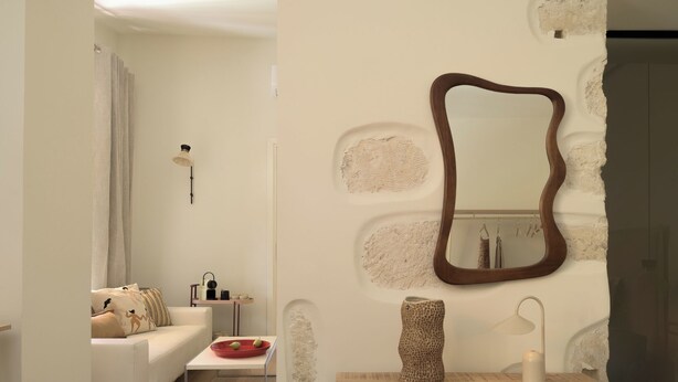 A modern living room with a white sofa, a small table, a mirror, and a lamp. - Two Bedroom Suite with Balcony, Spartacus Garden (Rethymno)