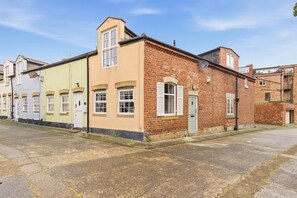 Eine Reihe terrassenförmig angelegter Häuser mit einer gepflasterten Straße dazwischen.