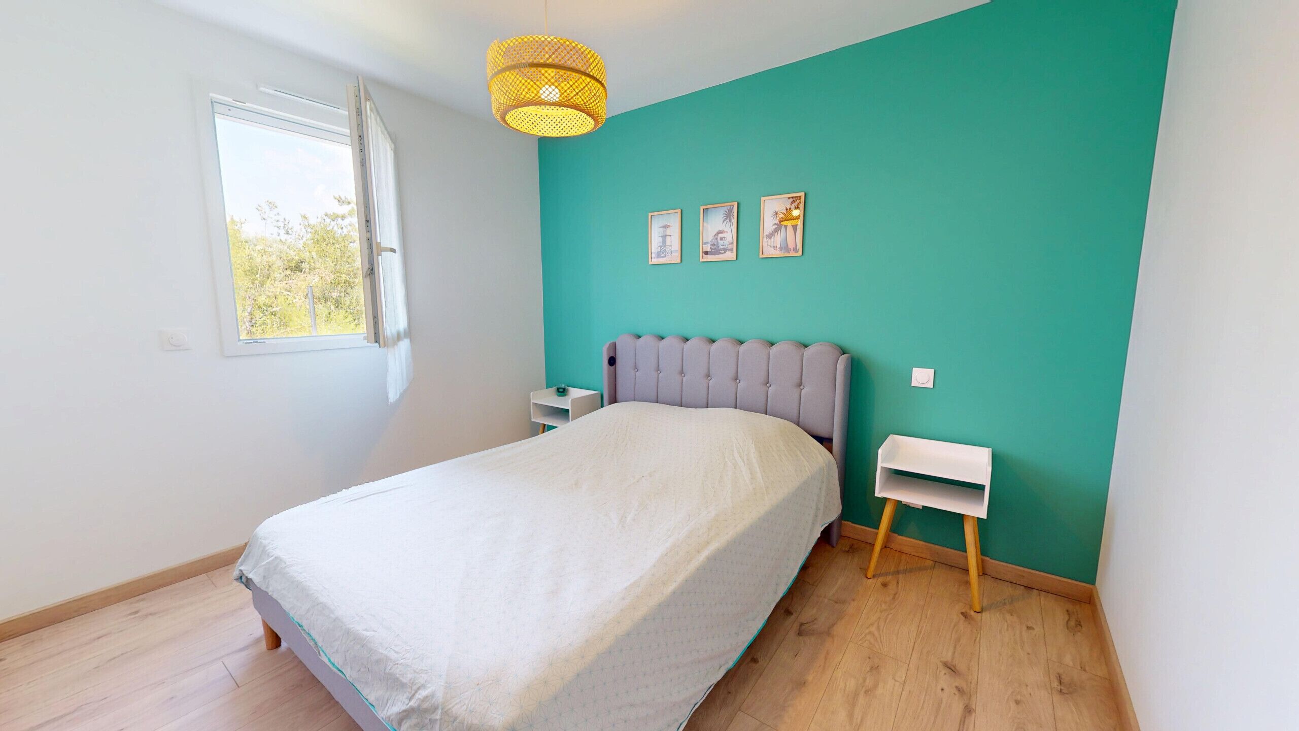 Une chambre à coucher avec un lit, une fenêtre, une table de chevet et une étagère fixée au mur.