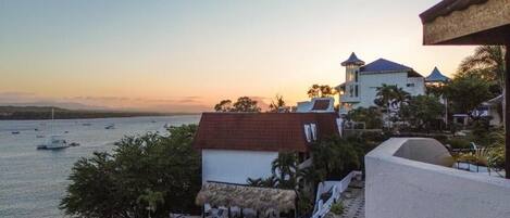 A resort with a pool, a beach, and a sunset view.