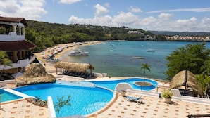 Un resort con piscina, spiaggia e vista sull'oceano.