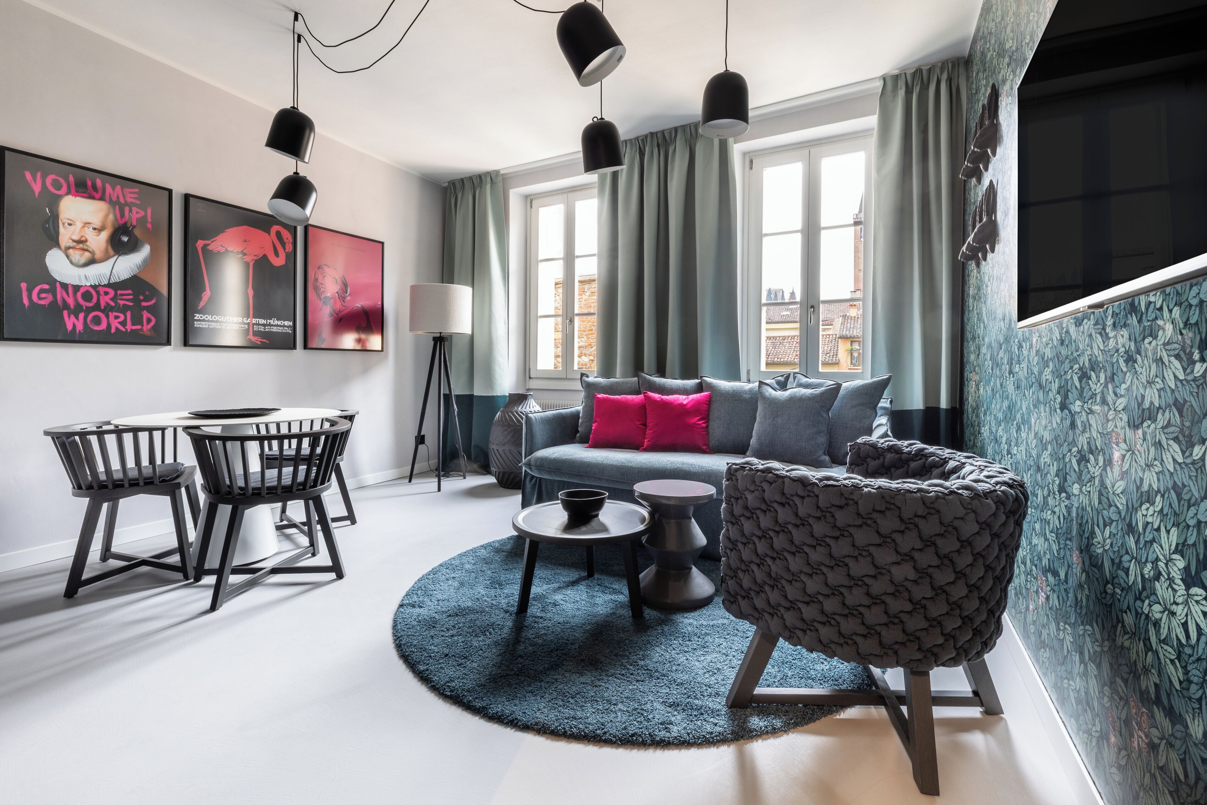 A modern living room with a sofa, chairs, a coffee table, and artwork on the wall.