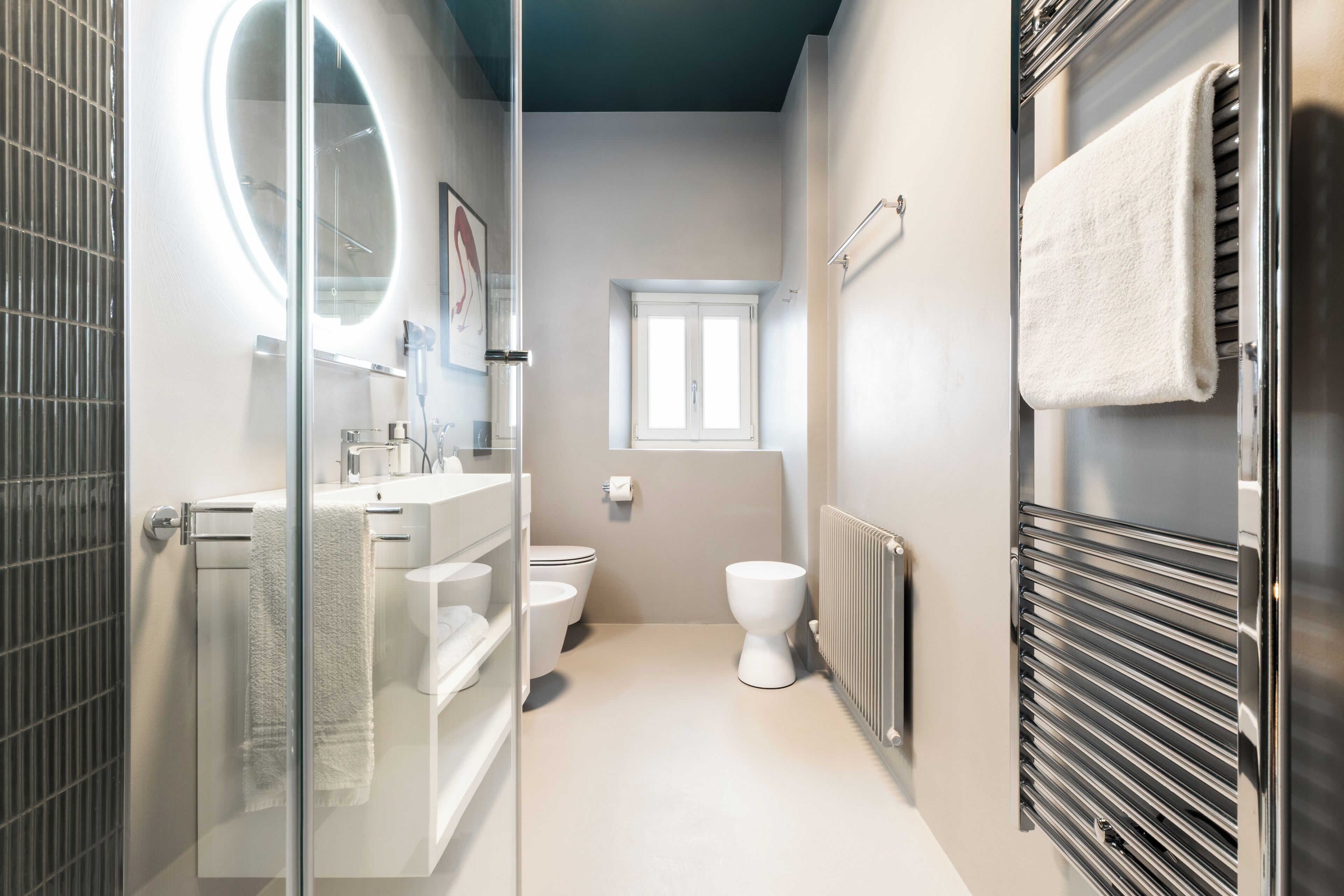 Ein modernes Badezimmer mit einer Duschkabine aus Glas, einer weißen Toilette und einem Handtuchhalter.