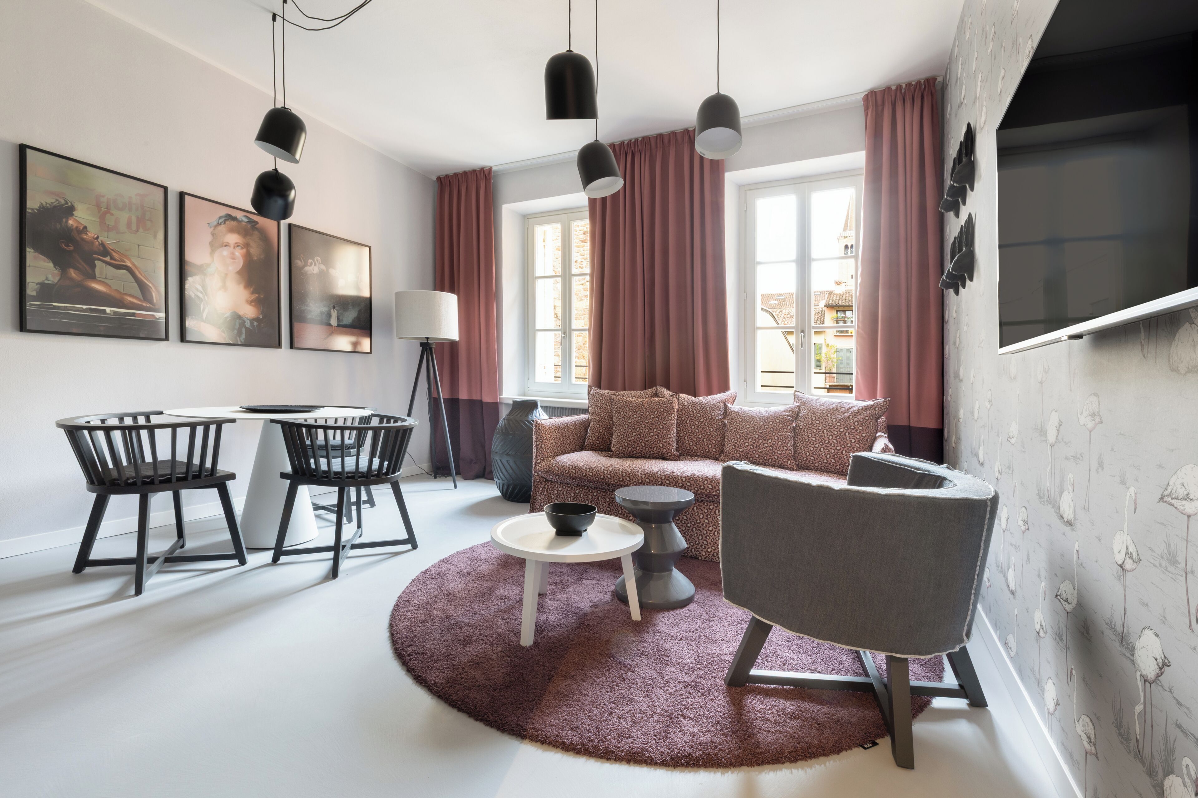 A modern living room with a sofa, chairs, a coffee table, and artwork on the wall.