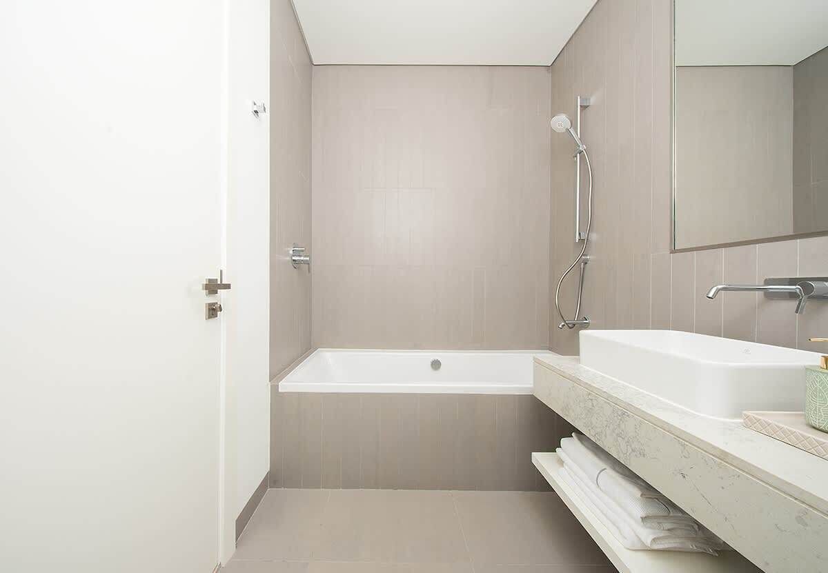 A modern bathroom with a bathtub, a shower, and a vanity with a mirror.