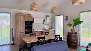 Una cocina moderna con armarios de madera, una mesa de comedor y lámparas colgantes de mimbre.