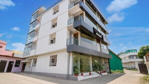 A multi-story residential building with balconies, a visible sign for a business, and a gated entrance. - Premium Valley View With Balcony Haldwani (Haldwani)