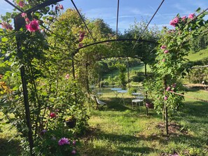 Un jardin agrémenté d’une pergola, de tables et de chaises.