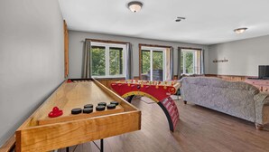 A room with a foosball table, a sofa, and a television. - Spa & Nature Retreat - Le Bercail (Entrelacs)