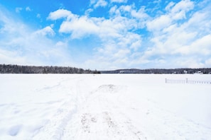 A snowy landscape with a clear sky and a path leading through the field. - Spa & Nature Retreat - Le Bercail (Entrelacs)