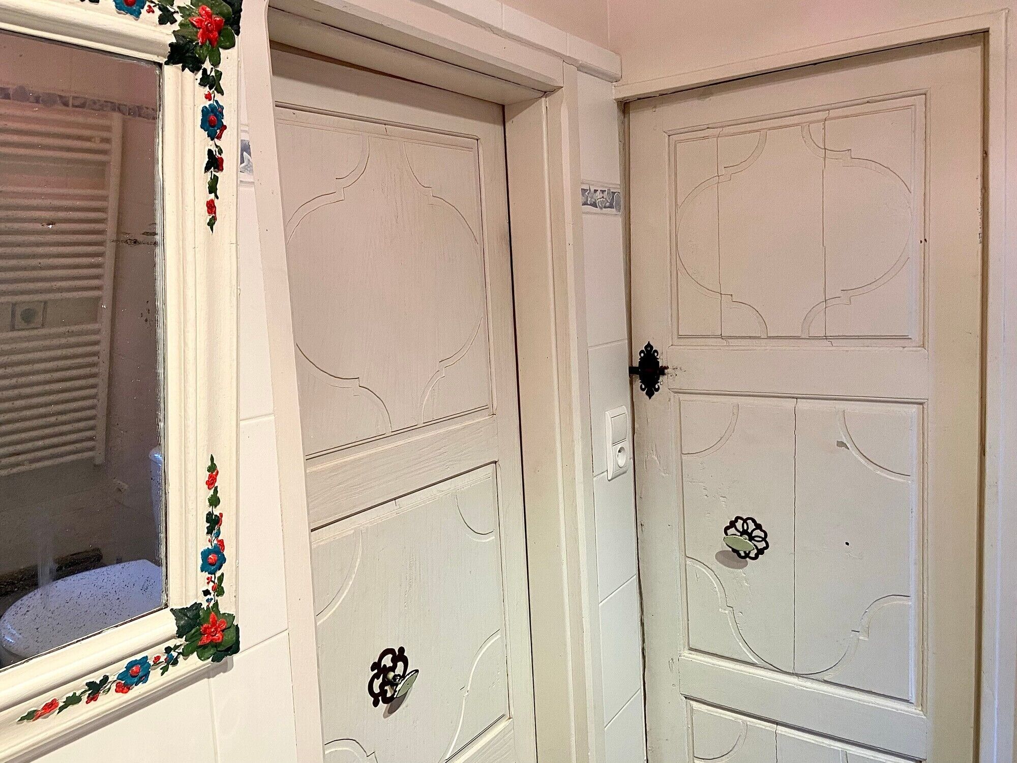 A white door with a decorative handle and a window with a floral design.