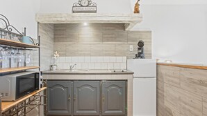 A kitchen with a microwave, a sink, and a refrigerator. There is a sign above the sink that reads 'CHATEAU ESTEPHE'. - Villa Esperanza – Air-Conditioned Studio with Sea View Terrace (Cavalaire-sur-Mer)
