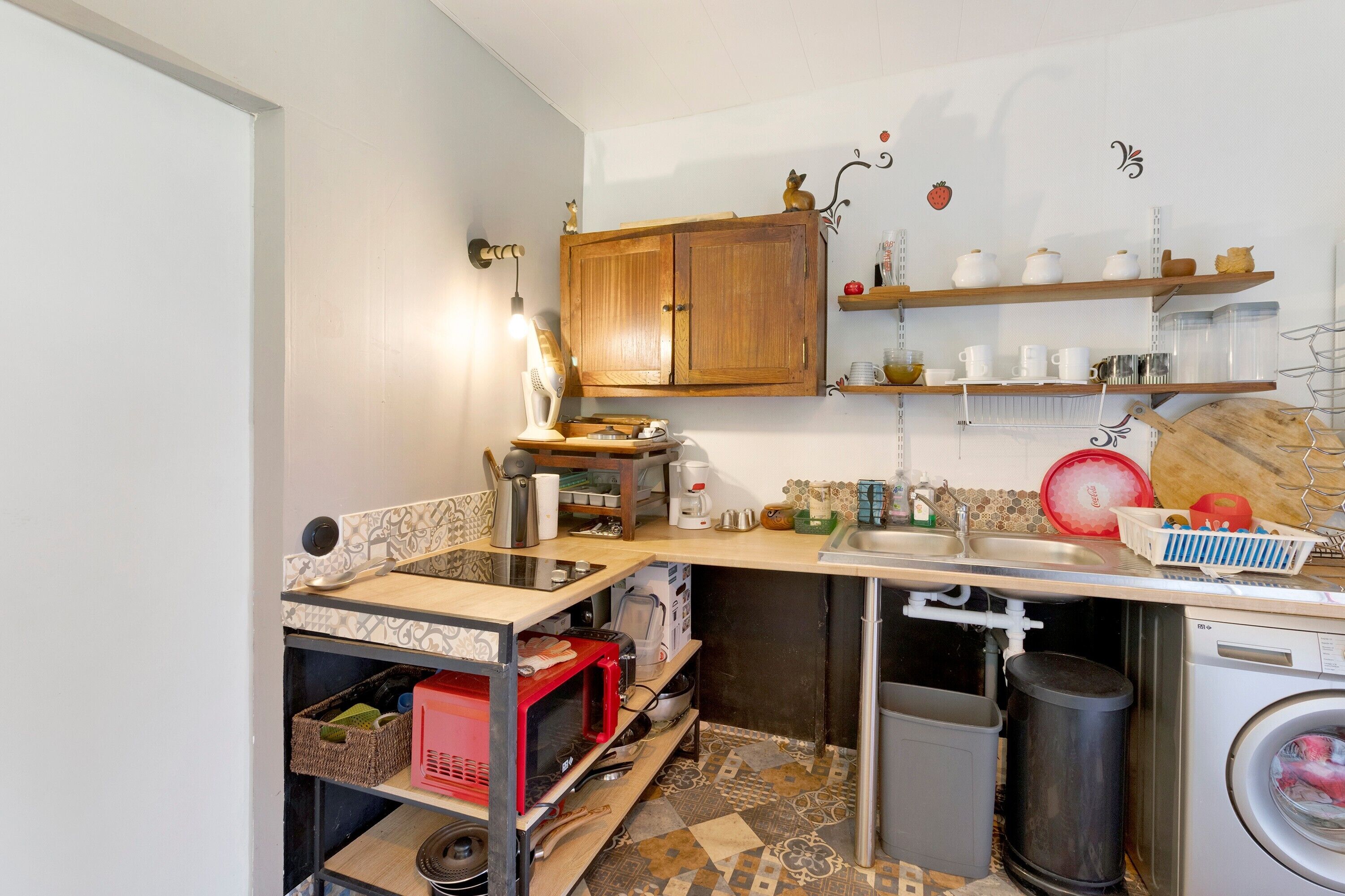 A compact kitchen with a microwave, toaster, and sink.