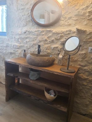 A stone wall bathroom with a round sink, a mirror, and a wooden vanity. - Guest Room D’ô with Shared Pool, Wi-Fi, and Air Conditioning (Frayssinet-le-Gélat)