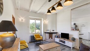 Una sala de estar moderna con una mesa de centro de madera, un sillón amarillo, un televisor y una chimenea.