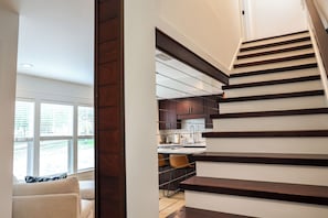Eine moderne Küche mit dunkler Holztreppe, die in einen zweiten Stock führt.