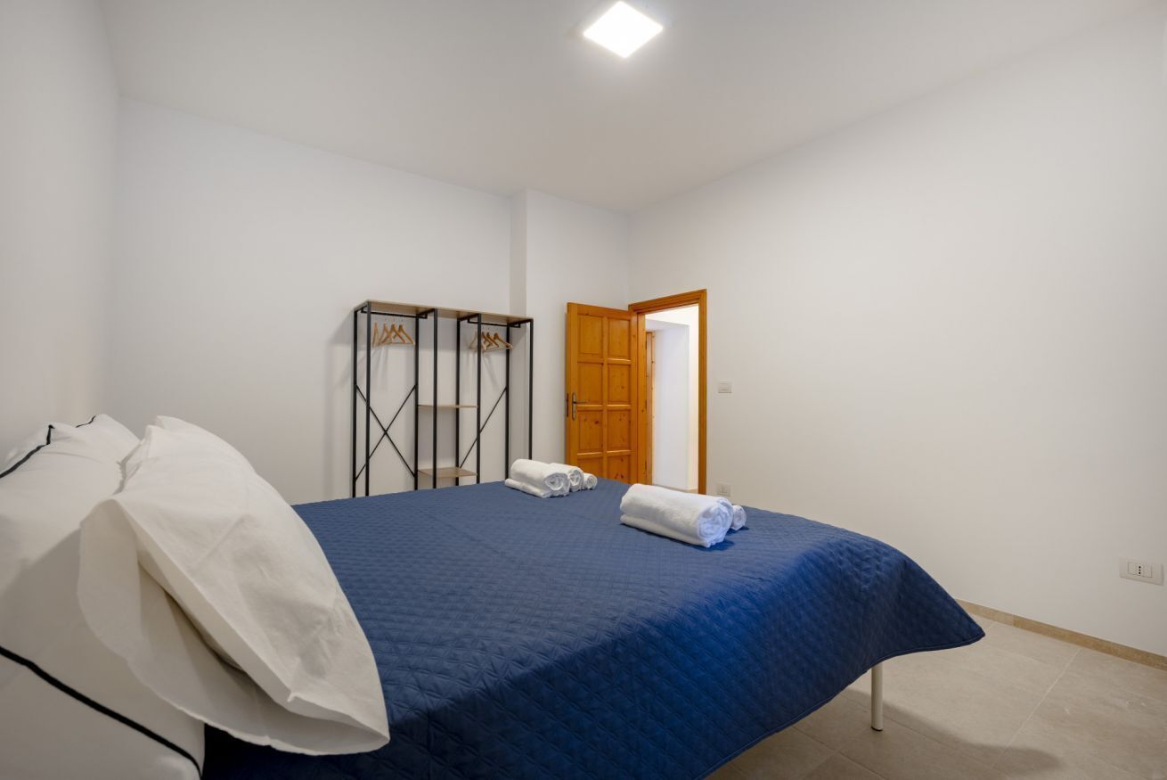 A bedroom with a bed, a wardrobe, and a door.