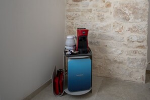 A coffee machine on a stand with a stone wall in the background. - Spacious double bedroom with living area and private bathroom, ideal for two, located within Trulli Italia, a complex of trulli with a shared garden. Surrounded by greenery, the accommodation is located in Selva di Fasano, a quiet and verdant hillside ha (Selva di Fasano)