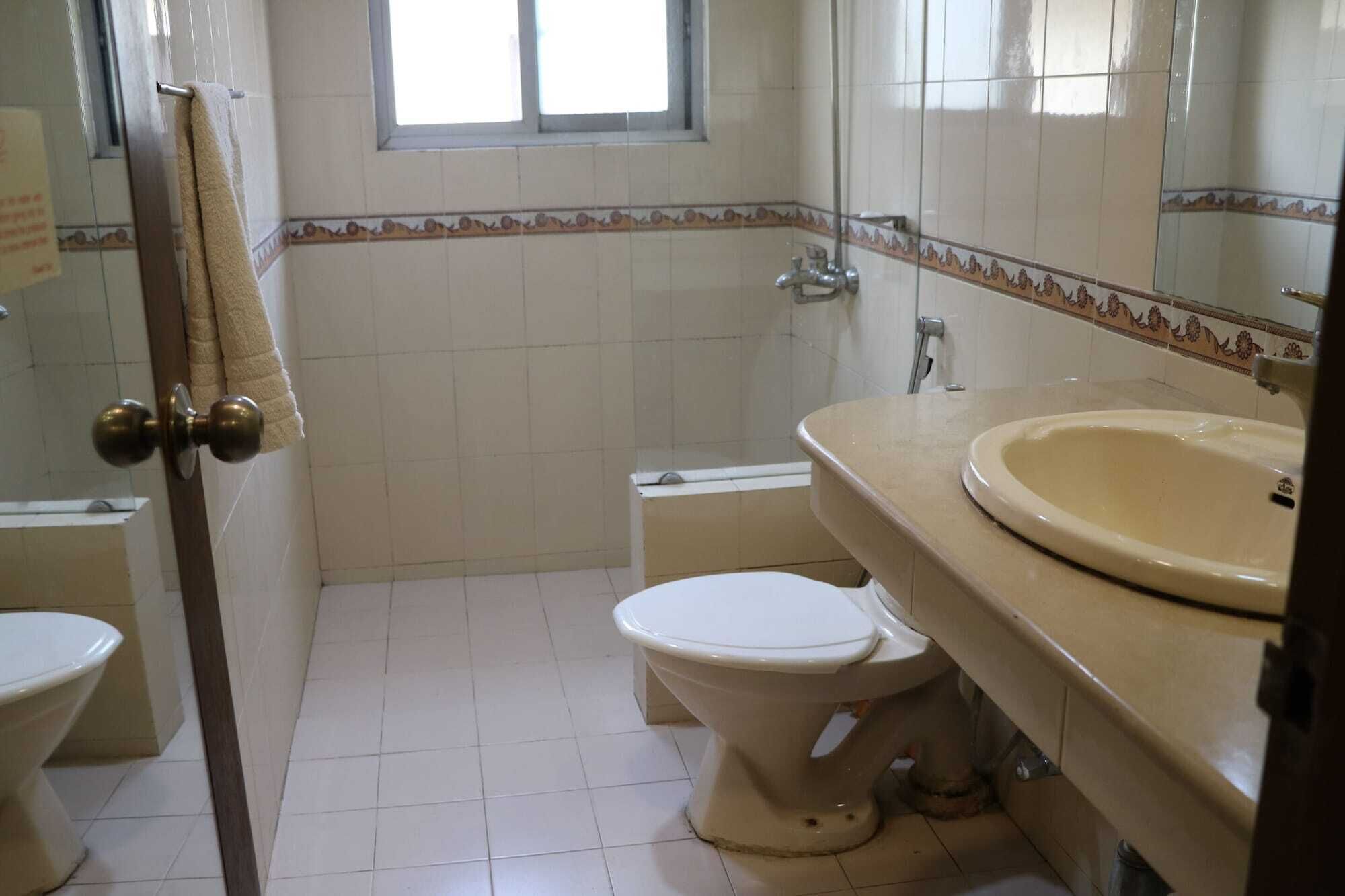Ein Badezimmer mit Toilette, Waschbecken und Fenster.
