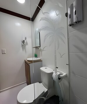 Ein Badezimmer mit Toilette, Waschbecken und Duschbereich.