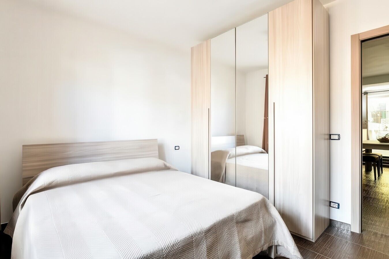 Une chambre à coucher avec un lit, une armoire et un miroir.