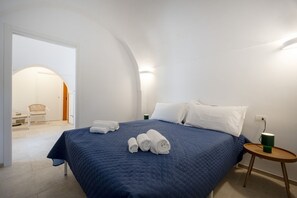 Ein Hotelzimmer mit Bett, Handtüchern, einem kleinen Tisch und einem Stuhl.