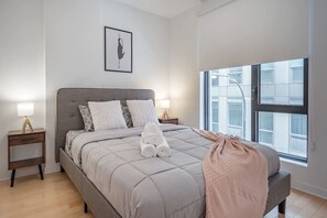 Una camera da letto moderna con un letto grande, due comodini, una finestra con vista e un quadro appeso al muro.