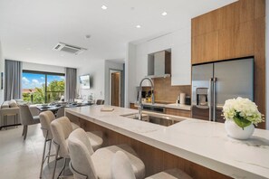 A modern kitchen with a marble countertop, stainless steel appliances, and a large window offering a view of the outdoors. - 2BR Condo w/ Pool & Jacuzzi, near Eagle Beach (Eagle)