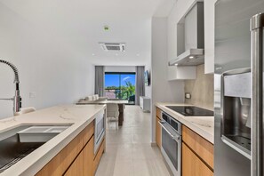 A modern kitchen with a built-in oven, a stainless steel refrigerator, and a window overlooking a balcony. - Garden View·Balcony·Pool & Jacuzzi·BBQ & Bar (Eagle)