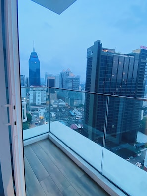 Ein Hochhaus mit Blick auf die Skyline durch einen Glasbalkon.