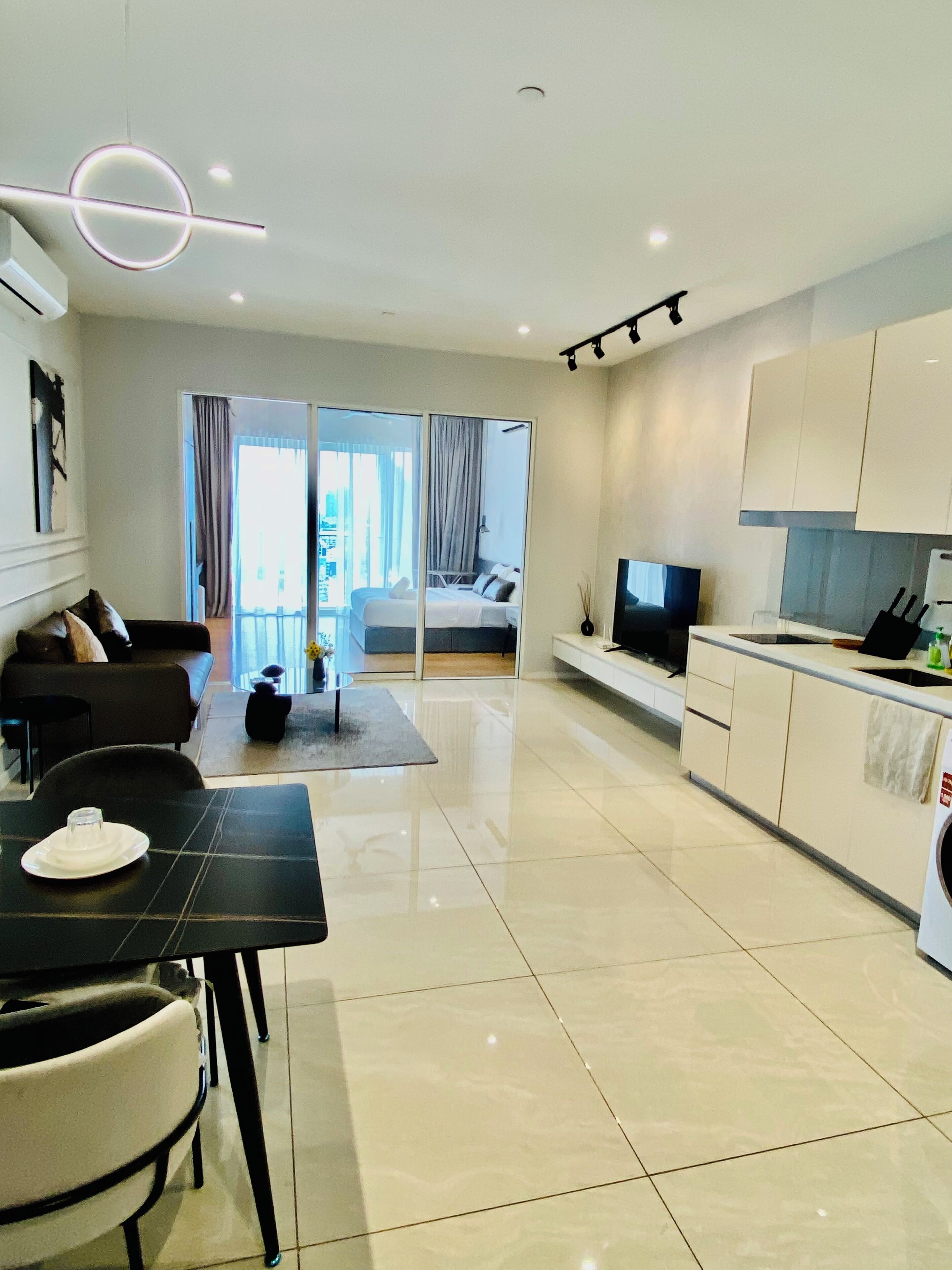 Eine moderne Wohnung mit Essbereich, Küche, Wohnzimmer und einem Balkon mit Blick.