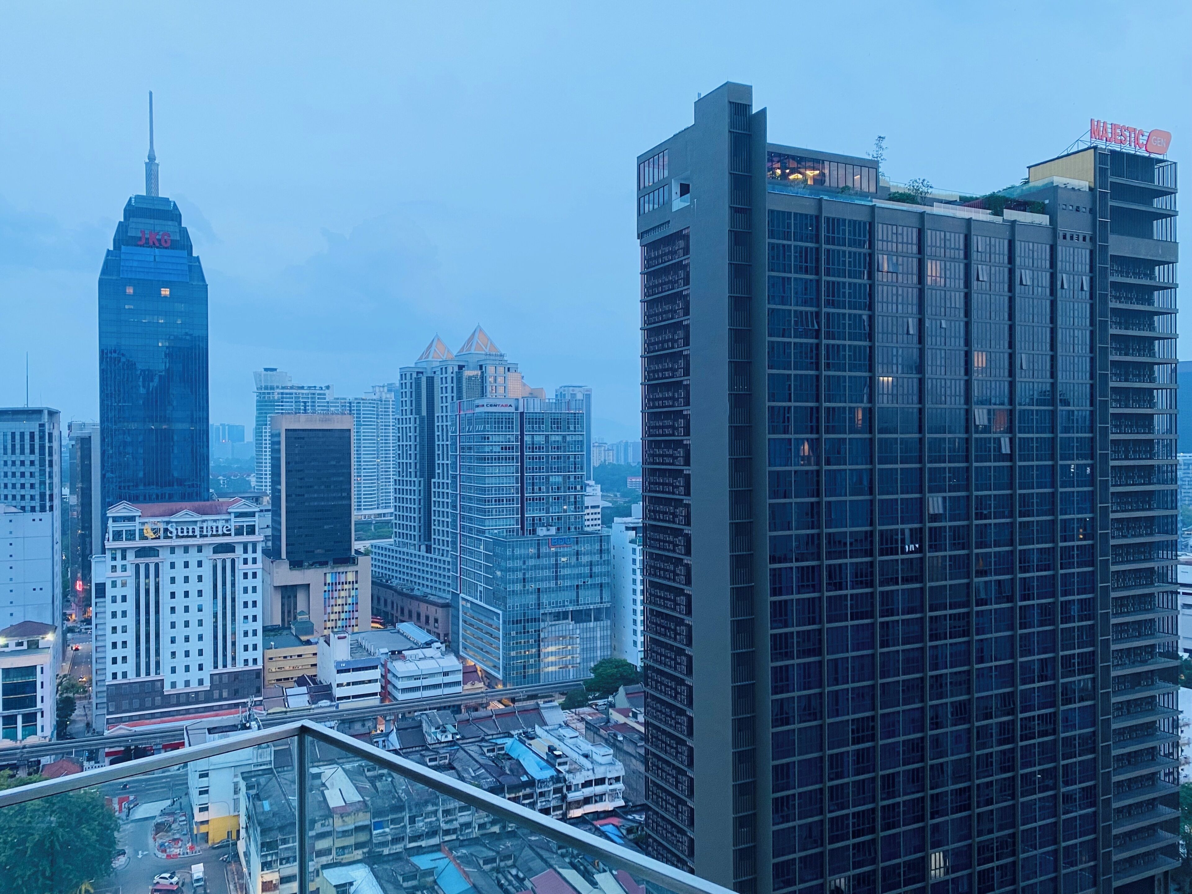 A high-rise building with a modern glass facade, a prominent antenna, and a sign reading 'MAJESTIC CENT'.