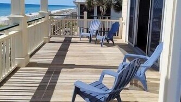 A wooden deck with chairs and a covered area, overlooking the beach. - Plantation at St George Island Fl. Beautiful beach view from all bedrooms (East Point)