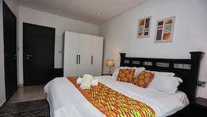 Ein Hotelzimmer mit Bett, Schrank, Nachttisch und Lampe.