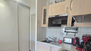 A compact kitchen with a refrigerator, microwave, toaster, and sink. - Bright apartment with balcony and swimming pool (Fréjus)