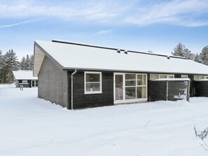 A modern building with a snow-covered roof, large windows, and a garage door. - 4 Star Holiday Home in Pandrup (Pandrup)