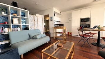 Un salon moderne avec un canapé, une table basse et des étagères.