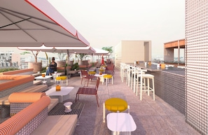 An outdoor seating area with tables and chairs, a covered section, and a view of the cityscape.