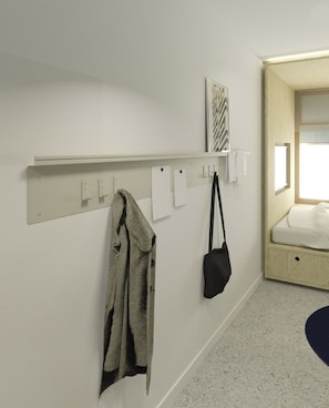 A hotel room with a bed, a wall-mounted shelf, and a coat rack. - Hôtel Super (Paris)