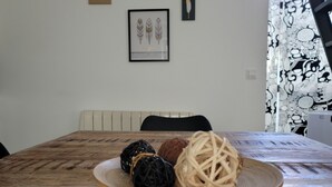 Un tavolo da pranzo in legno con un piatto di decorazioni sferiche e un quadro appeso al muro.