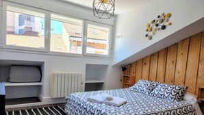 Una camera da letto con un letto, un termosifone, una finestra, un muro in legno e un lampadario a parete.