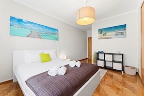 Ein Hotelzimmer mit einem Bett, einem Nachttisch, einer Lampe, einem Konsolentisch und zwei an der Wand befestigten Bildern.