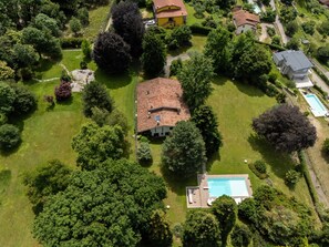 Vue aérienne d’un quartier résidentiel avec des maisons, une piscine et des jardins bien entretenus.