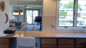 A kitchen with a large island, wooden cabinets, a ceiling fan, and a view through a window. - WATERFRONT HOME  Ocean Pines Dog Friendly (Ocean Pines)
