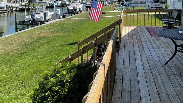 A wooden deck with a view of a marina and houses. - WATERFRONT HOME  Ocean Pines Dog Friendly (Ocean Pines)