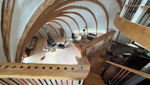 A high-ceilinged room with exposed wooden beams, a fireplace, and a staircase. - Oscar winning living @ Livingstations (Woodstock)