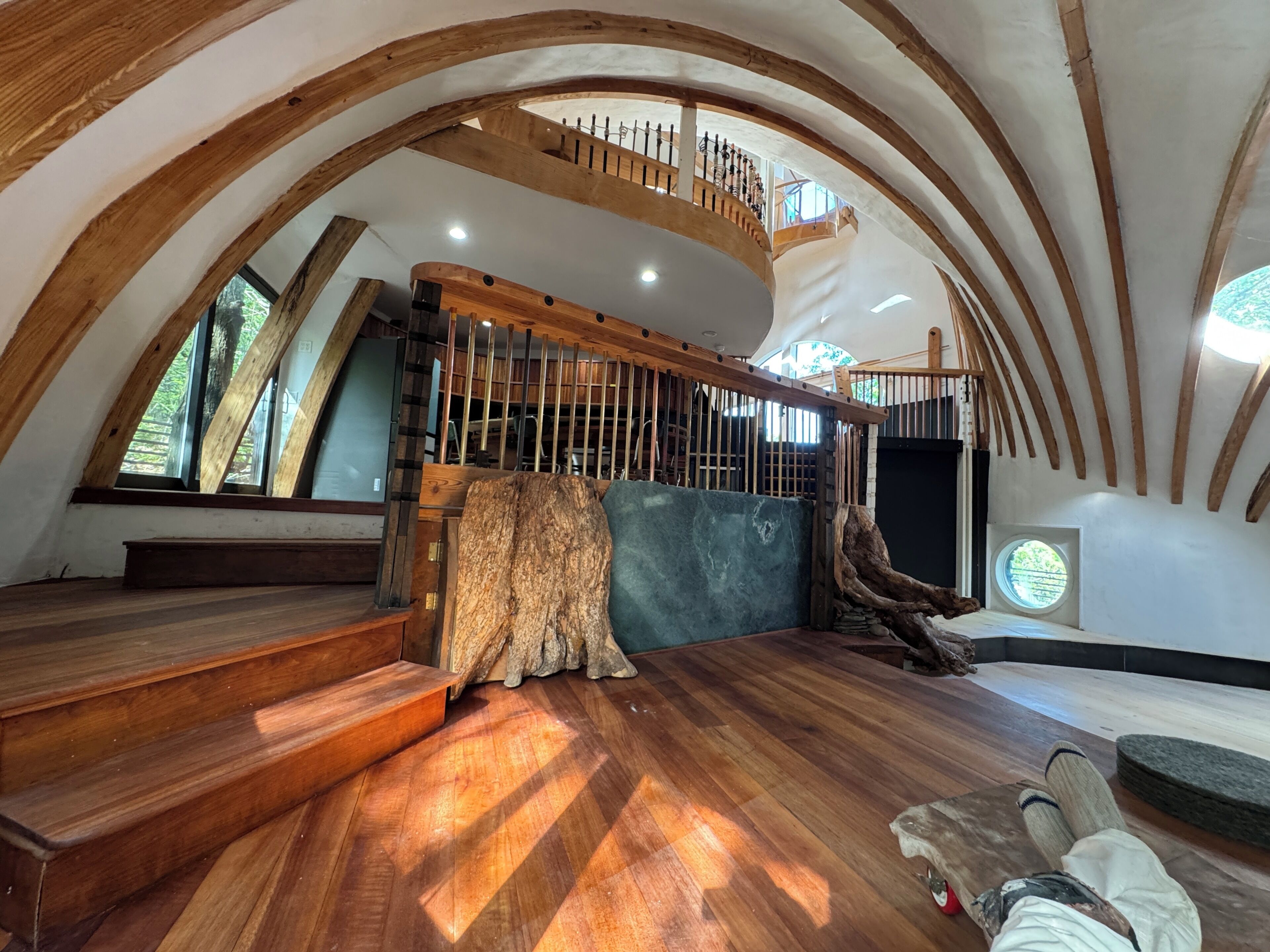 Un loft spacieux avec des poutres en bois, un escalier et une grande fenêtre.